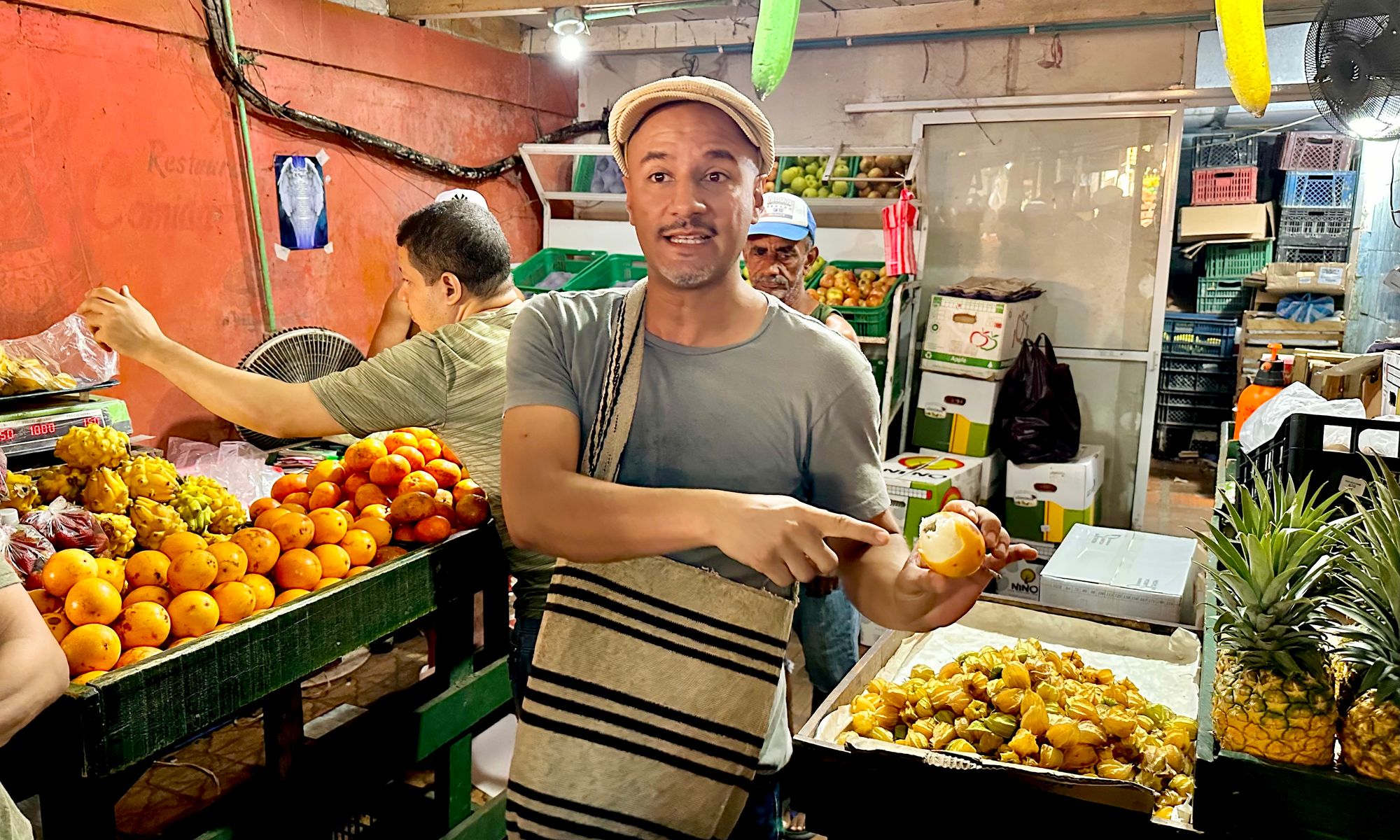Chef Andres shows us the Granadilla fruit at a market stall.